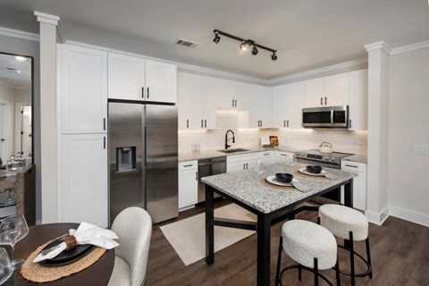 A modern kitchen with a dining table set for two.