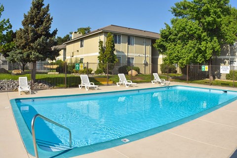 A swimming pool with a diving board in front of a building.