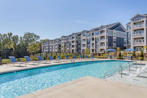 A swimming pool in front of apartment buildings.