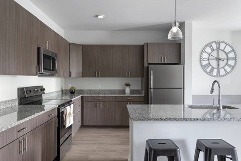 A modern kitchen with dark wood cabinets and stainless steel appliances.