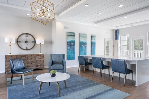 A modern living room with a white dining table and blue chairs.