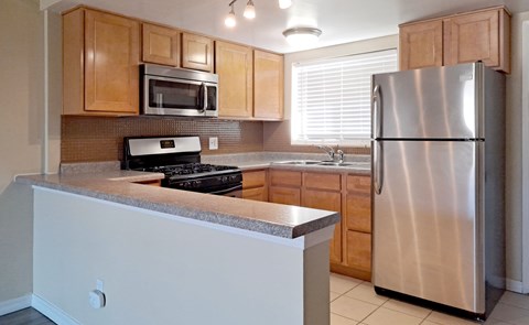 A kitchen with a stove top oven and a refrigerator.