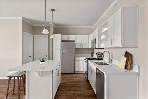 A modern kitchen with white cabinets and stainless steel appliances.