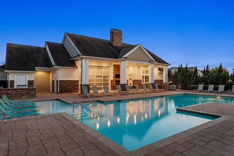 A house with a pool in front of it.