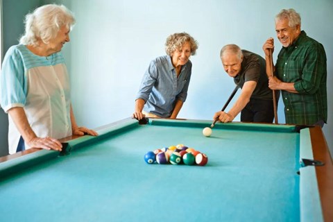 Four elderly people playing pool.
