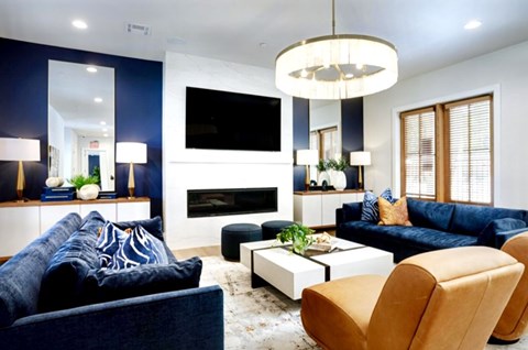 A modern living room with a blue couch and a white coffee table.