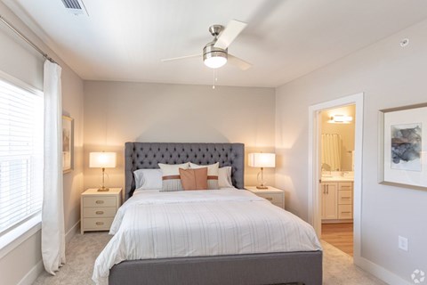 A bedroom with a large bed and a ceiling fan.
