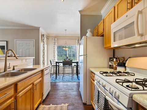 A kitchen with a white refrigerator and a white stove top oven.