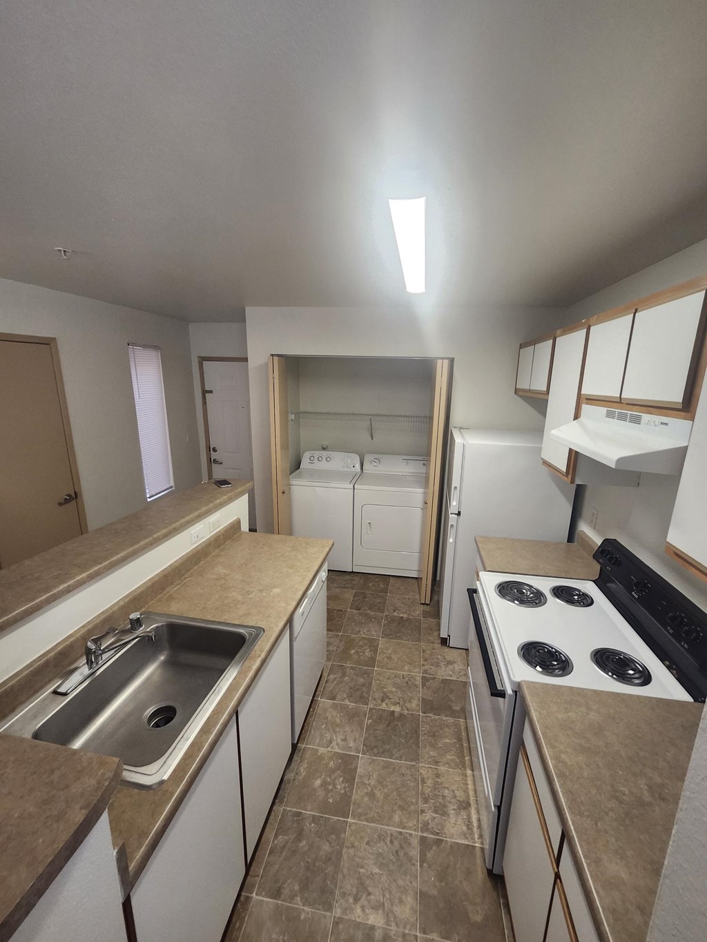 A kitchen with a stove top oven and a sink.