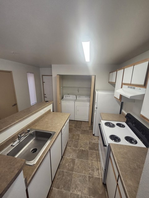 A kitchen with a stove top oven and a sink.