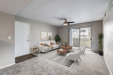 A living room with a grey carpet and a white sofa.