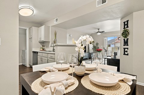 A dining room with a table set for a meal.
