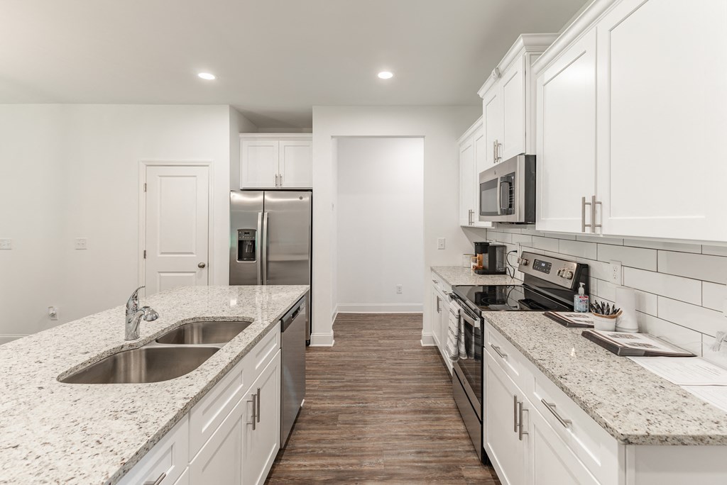a kitchen with white cabinets and granite countertops