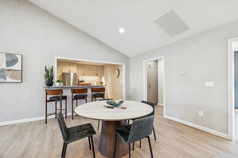 A modern dining room with a round table and chairs.
