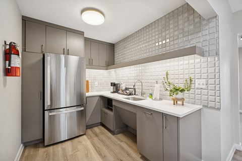 A modern kitchen with a stainless steel refrigerator and a white countertop.