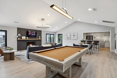 A pool table is in the middle of a living room.