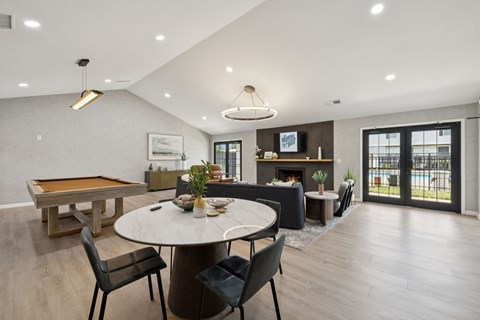 A modern dining room with a pool table and a fireplace.