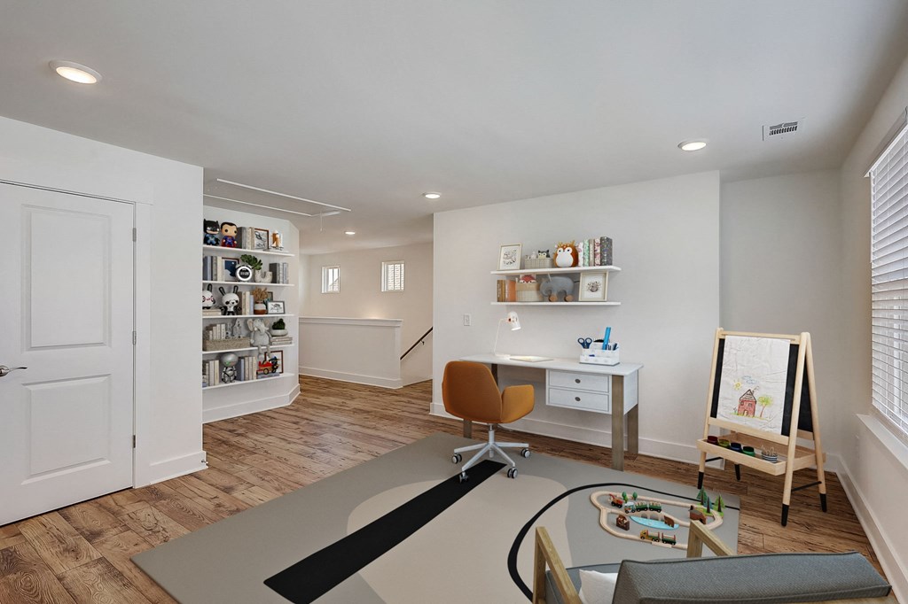a living room with a table and a chair and a desk with a easel