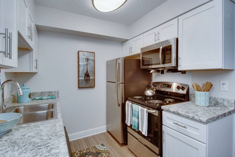 a kitchen with stainless steel appliances and white cabinets