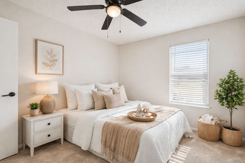 A bedroom with a bed, nightstand, and a ceiling fan.