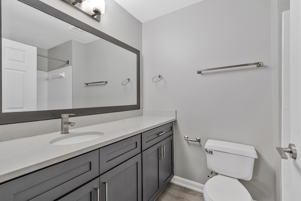 A white toilet sits next to a sink in a bathroom.