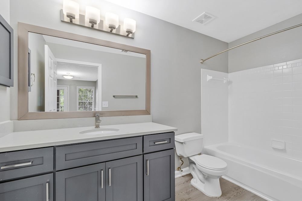 A bathroom with a white sink and a white toilet.