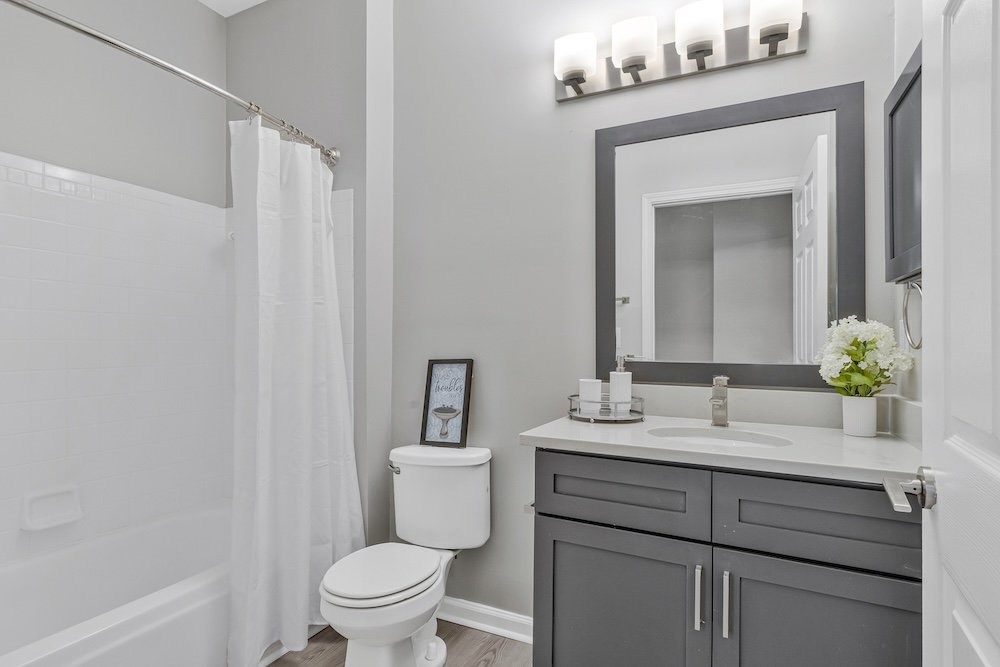 A white toilet sits next to a sink in a bathroom.