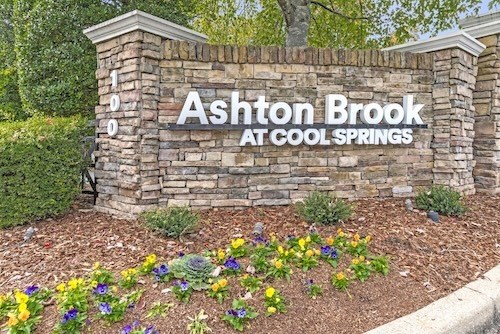 A sign that says "Ashton Brook at Cool Springs" is surrounded by flowers.