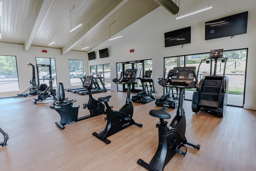 A gym with a row of stationary bikes.