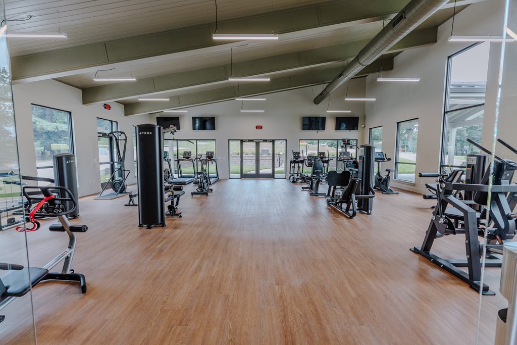 A gym with a variety of equipment including treadmills, weights, and exercise machines.