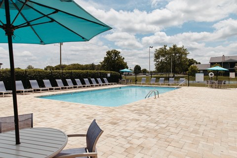 a swimming pool with chairs and umbrellas at the resort