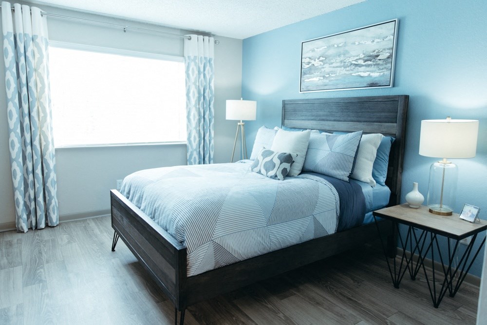 a blue and white bedroom with a bed and a window
