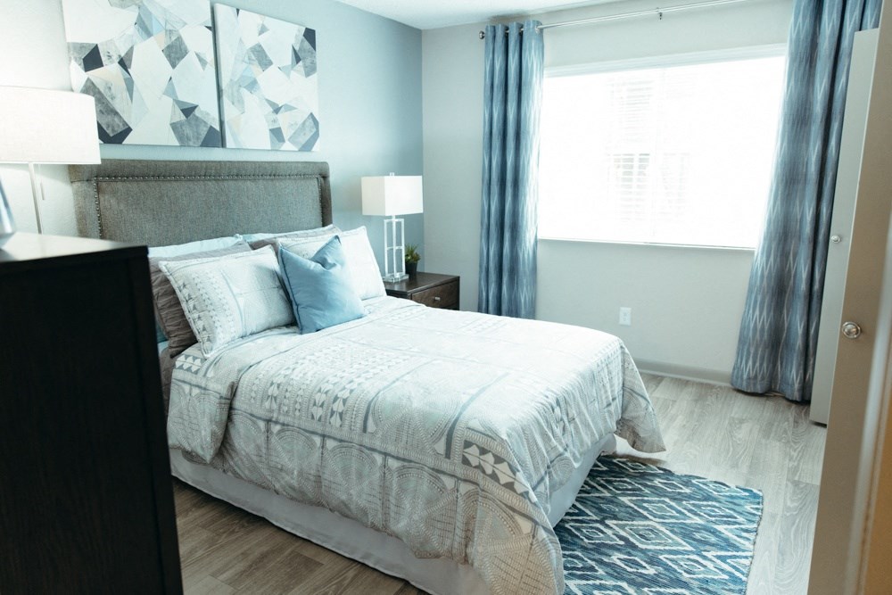 a bedroom with a bed and a dresser and a window