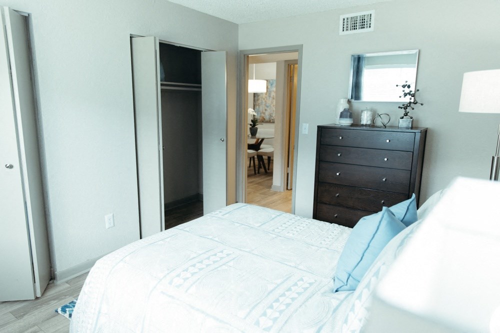 a bedroom with a bed and a dresser and a mirror