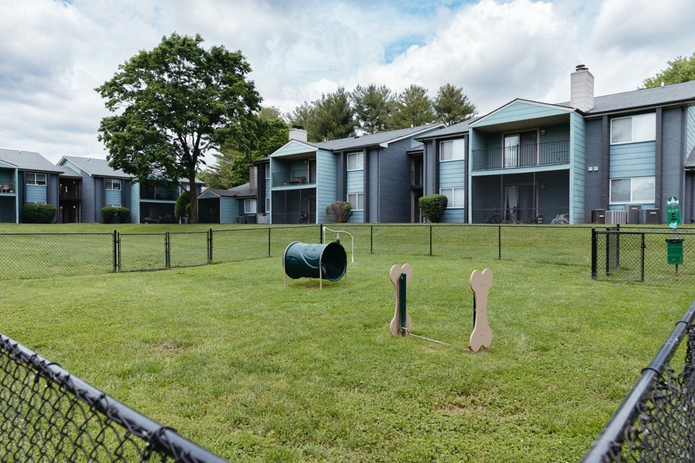 a group of apartment buildings with playground equipment in the grass