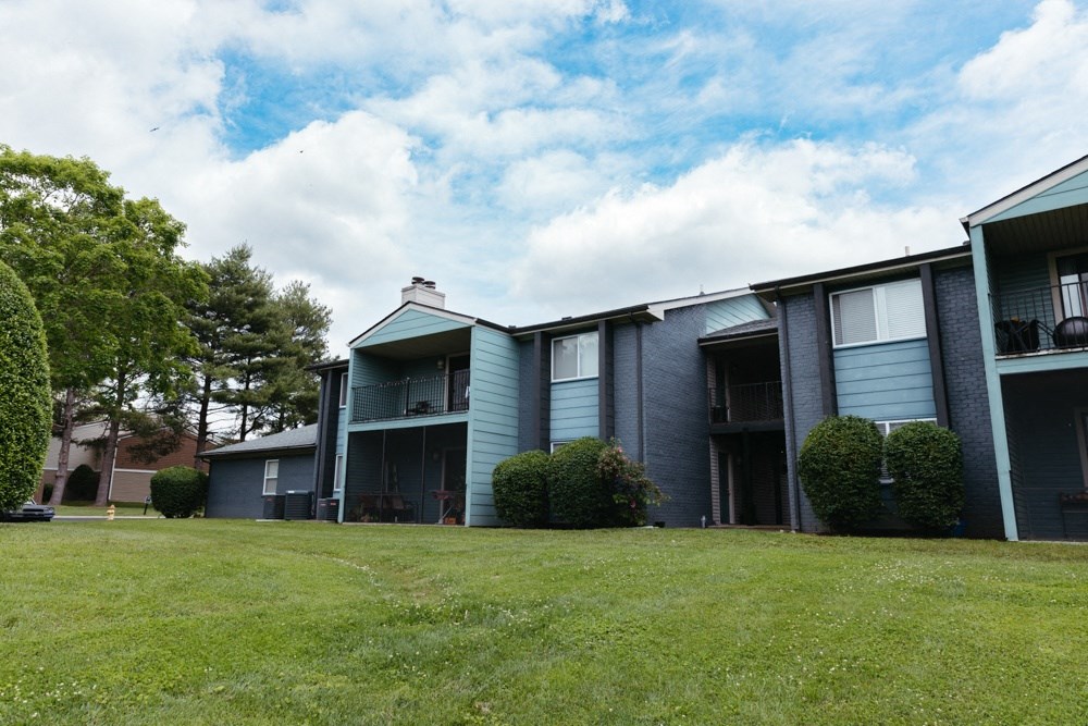 an apartment building with a green lawn in front of it