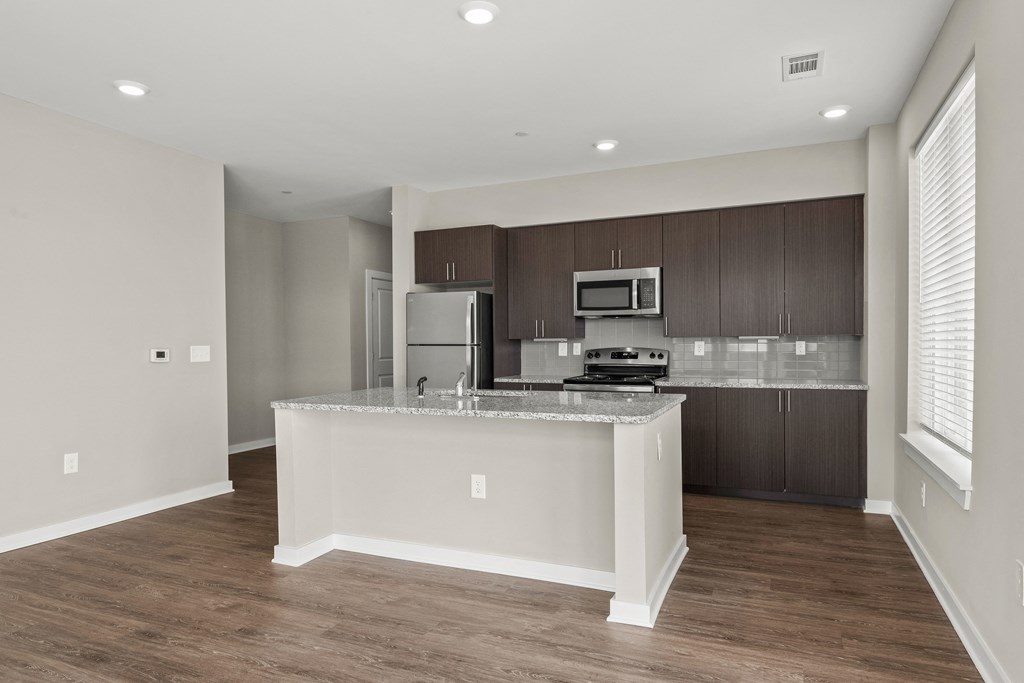 a kitchen with a large island and stainless steel appliances