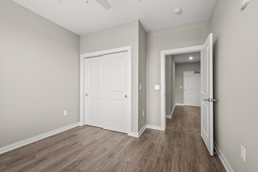 a bedroom with hardwood floors and grey walls