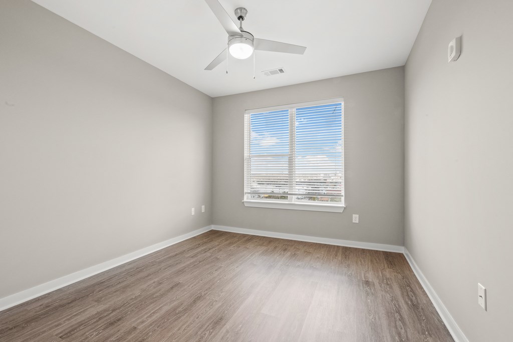 a bedroom with hardwood floors and a ceiling fan
