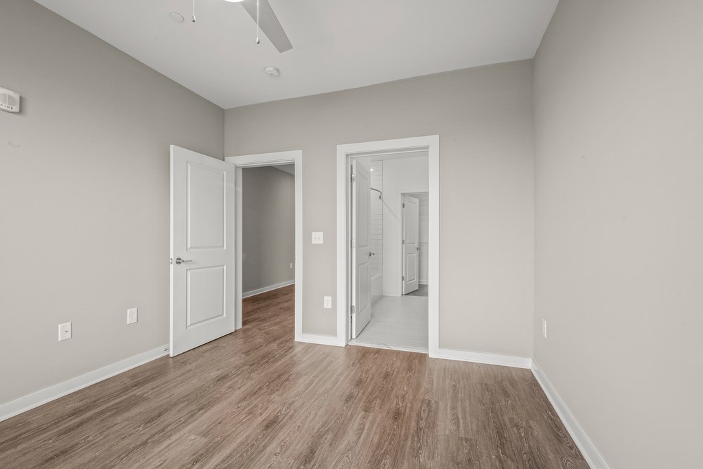 a bedroom with hardwood floors and grey walls