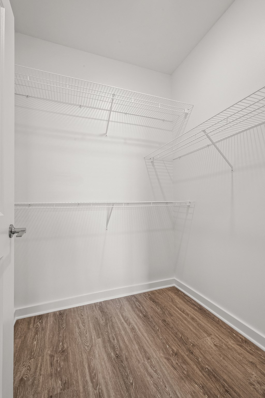 an empty room with white walls and a wooden floor