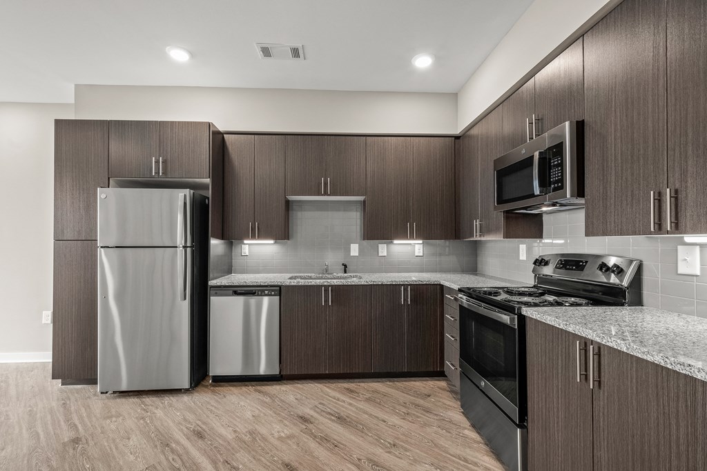 a kitchen with dark wood cabinets and stainless steel appliances