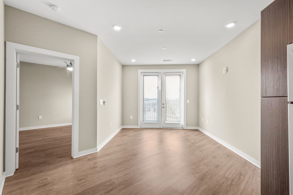 a bedroom with hardwood floors and white walls
