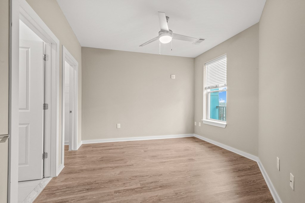 a bedroom with hardwood floors and a ceiling fan
