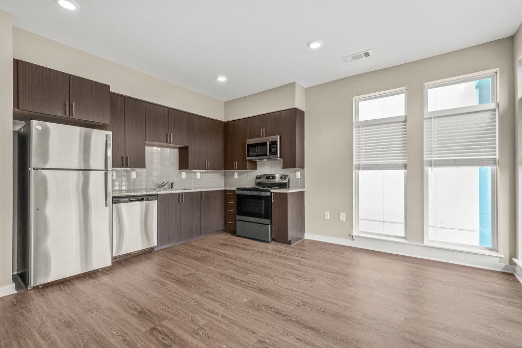 a kitchen with dark wood cabinets and stainless steel appliances