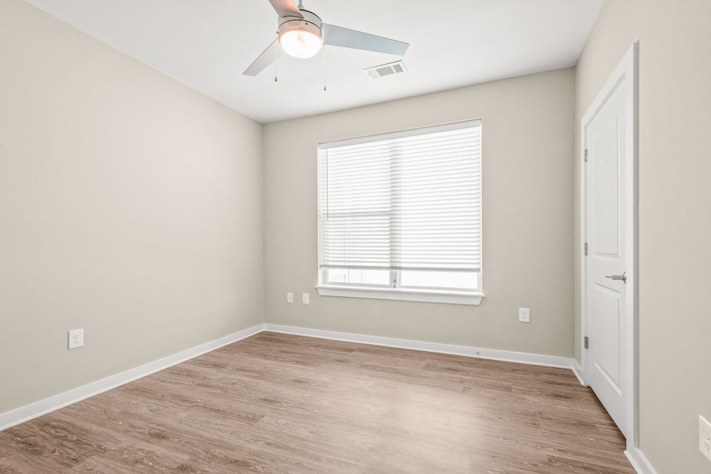a bedroom with hardwood floors and a ceiling fan