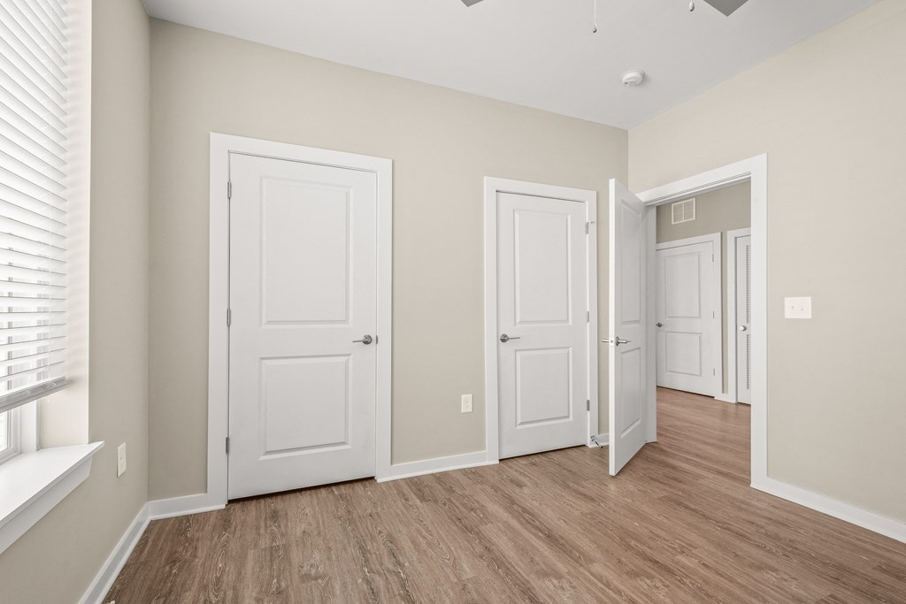 a bedroom with three doors and a window