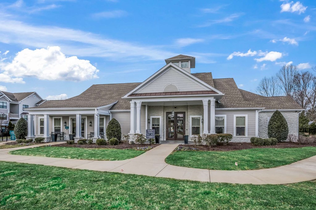 the front of a house with a walkway and grass
