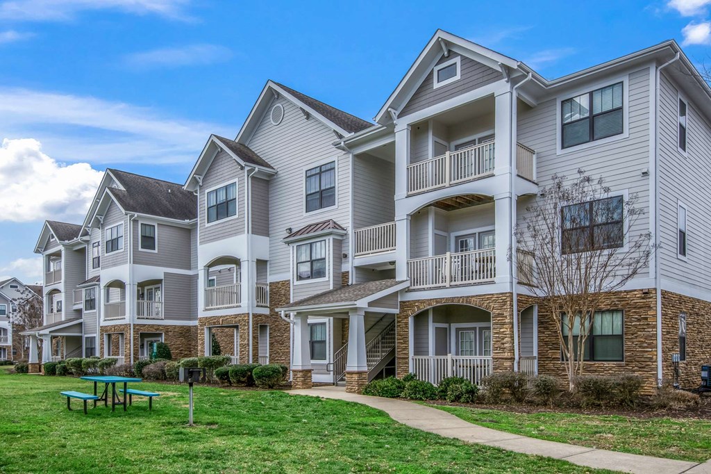 an exterior view of an apartment building with a picnic table