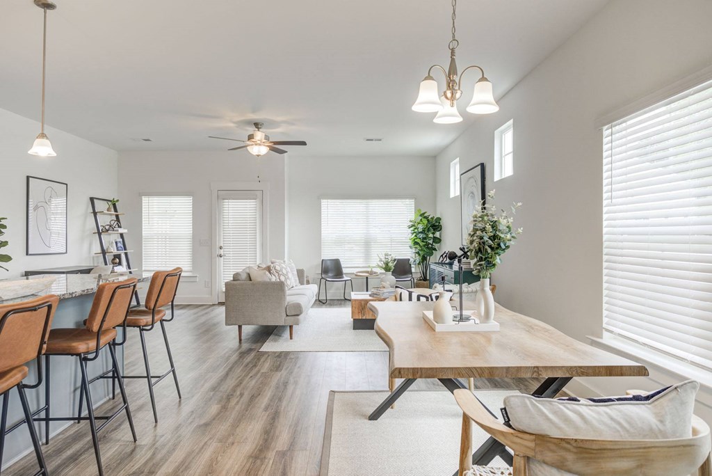 a living and dining room area with white walls and hardwood flooring